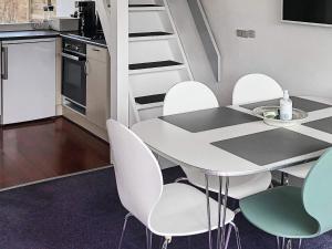 博托比5 person holiday home in V ggerl se的一间厨房,内设桌子和白色椅子