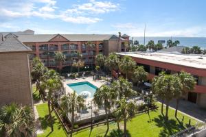加尔维斯敦Beachfront Palms Hotel Galveston的享有酒店空中景色,设有游泳池和棕榈树