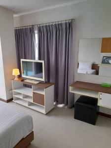 萨拉耶萨拉亚九月酒店的一间卧室配有一张床和一张书桌及电视