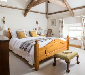 罗斯伯里Cragend Grange的一间卧室配有一张大床和一把椅子