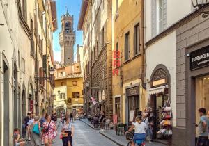 佛罗伦萨Old Convent in Via De Neri的一群人沿着街道走着,街道上有许多建筑