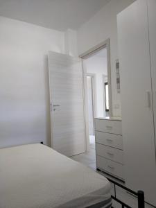 罗萨诺Oriental Park的一间白色卧室,配有一张床和一个梳妆台
