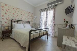 科林斯飞马客房旅馆的一间卧室配有一张带花卉壁纸的床