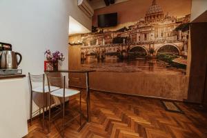 罗马隆达圣安吉洛套房旅馆的酒吧配有两把椅子,墙上挂着一幅画