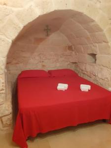 圣维托诺曼Trullo Oasi Maria的石墙中的一个红色床的房间