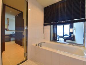 Kohama南群星酒店的带浴缸的浴室和窗户。