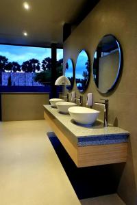 万加普Kambaniru Beach Hotel and Resort的浴室设有4个水槽和2面镜子