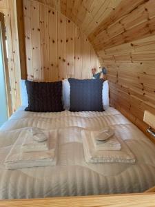 EarlishAllt Yelkie Pod Coig, Earlish的木制房间的一个床位,上面有两条毛巾