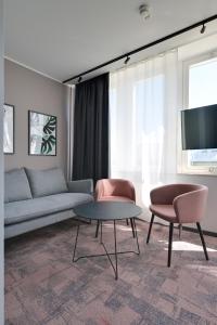 斯德哥尔摩Hotel Fridhem的客厅配有沙发、两把椅子和一张桌子
