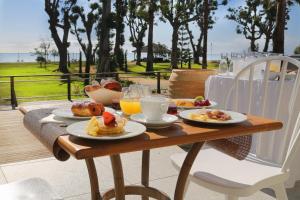 莫里亚尼海滩Hotel Restaurant San Lucianu的一张木桌,上面摆放着早餐食品和饮料
