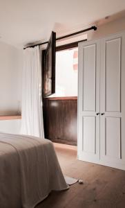 科尔多瓦La Ermita Suites - Único Hotel Monumento de Córdoba的卧室设有白色门和窗户