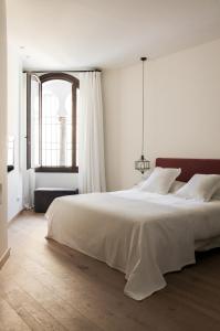 科尔多瓦La Ermita Suites - Único Hotel Monumento de Córdoba的白色的卧室设有一张大床和一个窗户