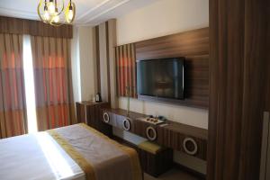 YıldırımBurçman Hotel Vişne的配有一张床和一台平面电视的酒店客房