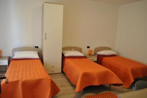 Sestu拉鲁克斯酒店的配有橙色床单的客房内的两张床