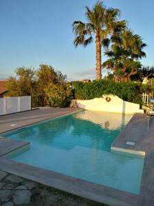 切法卢吉奥吉别墅住宿加早餐酒店的棕榈树后院的游泳池