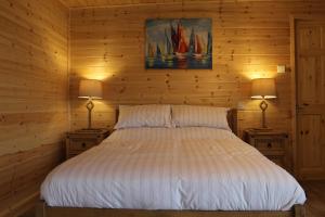PaullPaull Holme Farm Bed and Breakfast的一间卧室配有一张床,两台桌子上放着两盏灯