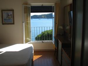 韦内雷港贝维德雷酒店的一间卧室配有一张床,享有水景