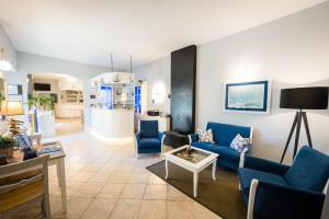 波尔图·埃尔科莱Hotel Conchiglia的客厅配有蓝色的沙发和椅子