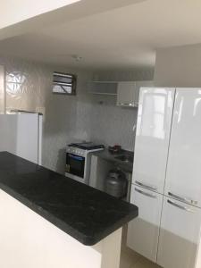 若昂佩索阿Ed. Oliveiro Lucena的白色的厨房配有炉灶和冰箱。