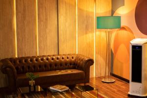 特雷西纳Jockey Class Hotel的客厅配有真皮沙发和灯具