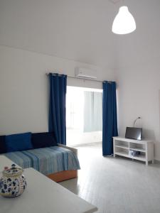 普罗奇达da Letizia的一间卧室配有床和蓝色窗帘的窗户