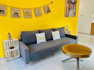 凯日马罗克Apartmán Kežmarok的客厅设有蓝色的沙发和黄色的墙壁