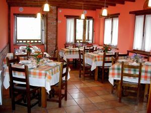 Dobres拉波萨达德卡尤旅馆的一间设有桌椅的餐厅,位于带橙色墙壁的房间