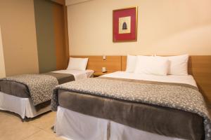 阿帕雷西达Hotel Porto Real Aparecida的一间酒店客房,房间内设有两张床