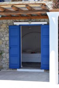 帕诺尔莫斯米科诺斯伊里尼别墅的蓝色的门,里面有一张床