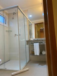 阿帕雷西达Hotel Porto Real Aparecida的带淋浴和玻璃淋浴间的浴室