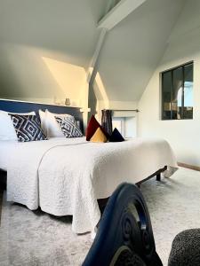 RévilleLa Maison Gervaiserie & Spa的卧室配有带枕头的大型白色床