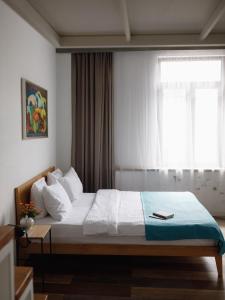 巴统Mariinsky Boutique Hotel的一间卧室设有一张大床和窗户