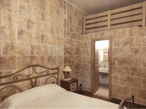 耶罗里明Perimenis Seaside House的一间卧室设有一张床和石墙