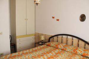 ZancaCasa Miclara - Bilocale Limoni的一间卧室配有一张带橙色毯子的床