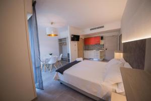 加尔达湖滨克里斯廷妮住宅酒店的一间带白色大床的卧室和一间厨房