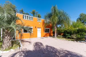 波特苏埃洛Las Coloniales的一座种植了棕榈树的橘子房子