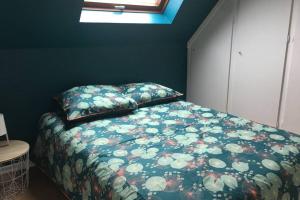EckwersheimGîte alsacien的一间卧室配有一张带花卉棉被的床和窗户。