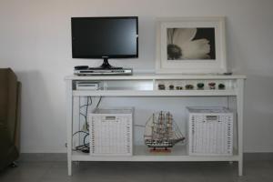 夫塞塔弗泽塔海滩度假公寓的电视位于白色架子上,配有电视