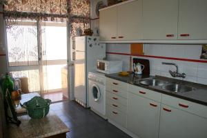夫塞塔弗泽塔海滩度假公寓的厨房配有水槽和冰箱