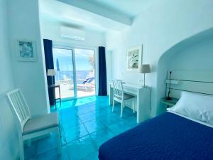 伊斯基亚Hotel Casa Sofia的一间卧室设有一张床和一张书桌,享有海景