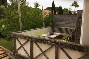 波克罗勒岛Appartement à 100 m du village de porquerolles的阳台的天井配有桌椅