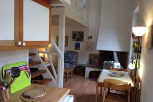 波克罗勒岛Appartement à 100 m du village de porquerolles的厨房以及带楼梯和桌子的客厅。