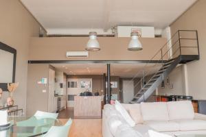 奥德纳尔德luxurious loft Oudenaarde in The Flemish Ardennes的客厅设有白色沙发和楼梯。