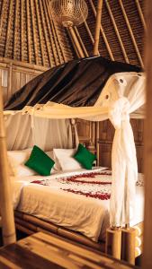 珀尼达岛Penida Bambu Green Suites的一间卧室配有一张带天蓬的床