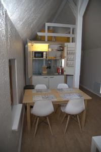EckwersheimGîte alsacien的一间带木桌和白色椅子的小厨房