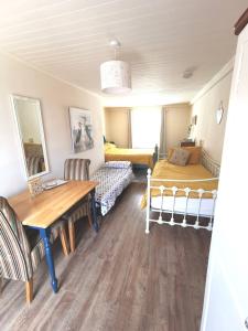 巴利马尼The Nook @ Rowan Tree Cottage的一间带桌子和床的房间以及一间卧室