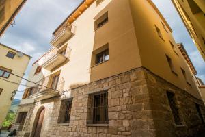 Alós de BalaguerCal Negret Rural Apartments的黄色建筑的侧面设有窗户