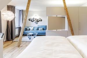 博登湖畔克雷斯波洛弗里埃辛格精品酒店的客厅配有两张床和蓝色的沙发