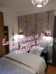 勒特雷波尔Ô bord de L' eau的一间卧室,配有一张床上 ⁇ 虹灯标志的床