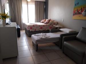 萨尔瓦多Farol da Barra 209的带沙发、床和桌子的客厅